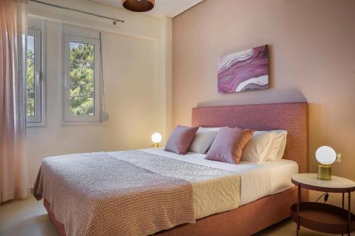 a bedroom with a large bed with two windows at Deluxe Kefalonia Apartment Apartment Perla 1 Bedroom Pool Sea View Karavomilos in Karavomylos