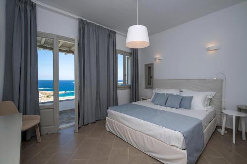 a bedroom with a bed with a view of the ocean at Platinum Paros Villa 3 Bedroom Villa Amazing Sea Views & Private Infinity Pool Access Parikia in Parasporos