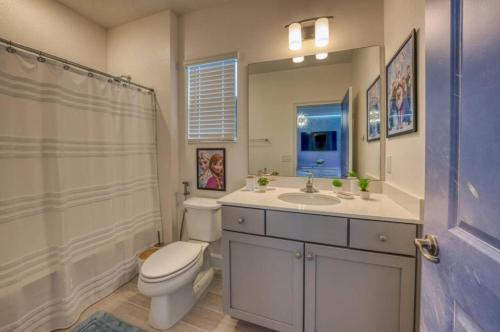 a white bathroom with a toilet and a sink at Experience Luxury In Your 11 En-suites Mansion in Orlando