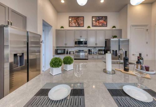 a large kitchen with a counter with two glasses on it at Experience Luxury In Your 11 En-suites Mansion in Orlando