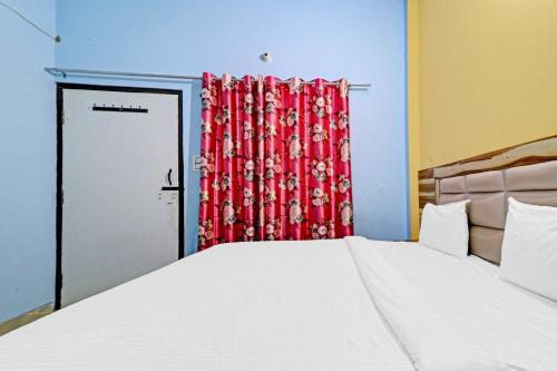 a bedroom with a bed and a red curtain at Hotel O Knight guest house in Morādābād