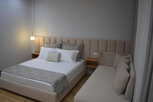 a small bedroom with a bed and a couch at PLATINUM ApartmentsINNThebeach in Vlorë