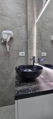 a bathroom with a black bowl sink on a counter at PLATINUM ApartmentsINNThebeach in Vlorë