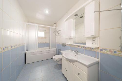 a white bathroom with a sink and a toilet at Avsallar Kepenek Village in Avsallar