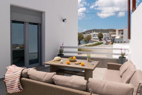 a patio with a couch and a table on a balcony at Almyra House in Adamas