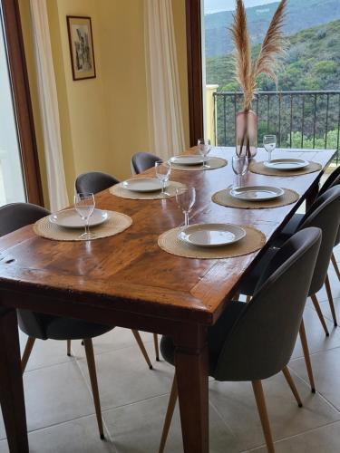 a wooden table with chairs and plates and wine glasses at Villa Farangi in Gállos