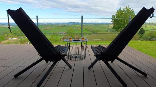 two chairs and a table on a wooden deck at Villaggio Brambui Durando in Portacomaro