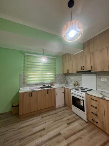 a kitchen with wooden cabinets and a white stove top oven at Mitrovi Apartment in Gevgelija