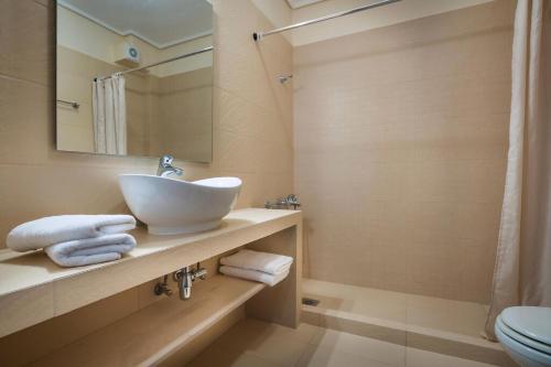 łazienka z umywalką, toaletą i lustrem w obiekcie Deluxe Kefalonia Apartment Apartment Lotos 3 Bedroom Sea View Karavomilos w mieście Karavomylos