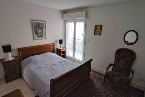 une chambre avec un lit, une chaise et une fenêtre dans l'établissement Spacious apartment for 6 with balcony, à Saint-Raphaël