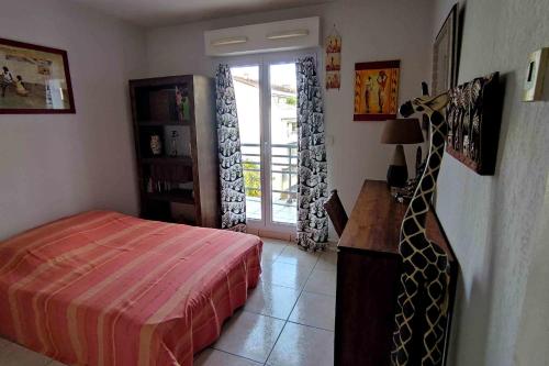 - une chambre avec un lit et une porte donnant sur un balcon dans l'établissement Spacious apartment for 6 with balcony, à Saint-Raphaël