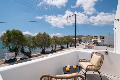 a balcony with chairs and a view of the water at Almyra House in Adamas