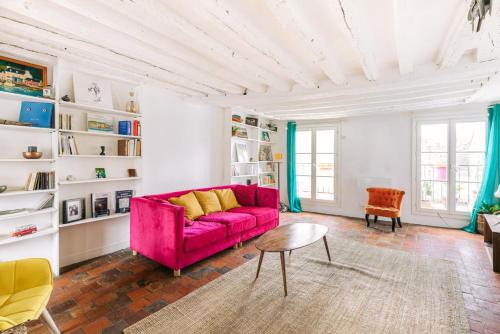 un salon avec un canapé rouge et une table dans l'établissement GuestReady - Le Marais getaway with a balcony, à Paris