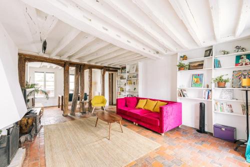 un salon avec un canapé rouge et une table dans l'établissement GuestReady - Le Marais getaway with a balcony, à Paris