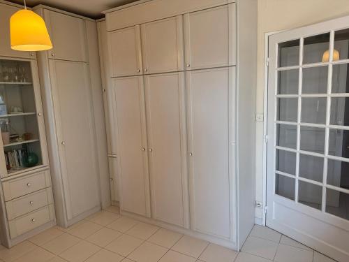 une cuisine avec des armoires blanches et une fenêtre dans l'établissement Charmant studio en front de mer avec balcon, à Saint-Raphaël