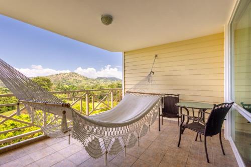 a hammock on a balcony with a table and chairs at Gamboa Rainforest Reserve in Gamboa