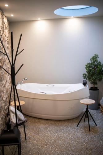 a bath tub in a bathroom with a blue ceiling at Rooster Suites in Athens