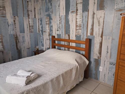 a bedroom with a bed with towels on it at Pousada D'amoras in Conservatória