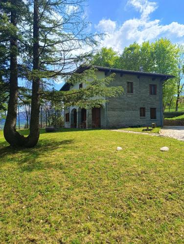 ein Haus mit einem Baum vor einem Hof in der Unterkunft Villa Giordani affittacamere Boscoreale in Piandelagotti