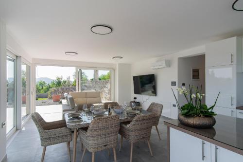 a kitchen and dining room with a table and chairs at Villa Rosemary Trieste HerMes arT in Sežana