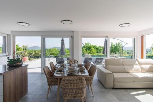 a living room with a white couch and a table and chairs at Villa Rosemary Trieste HerMes arT in Sežana