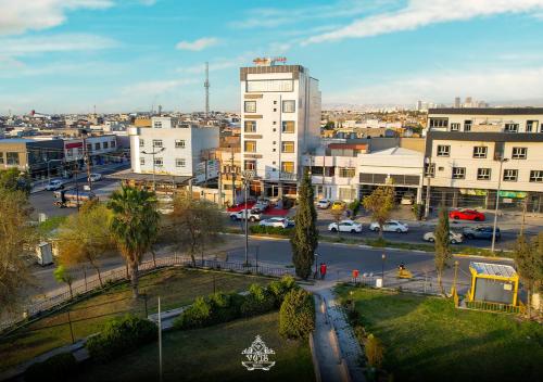 an aerial view of a city with a parking lot at Vote Hotel 1 in Erbil