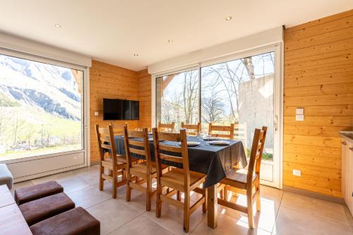 une salle à manger avec une table, des chaises et des fenêtres dans l'établissement Le Nid d'Aigle, à Saint-Sorlin-dʼArves