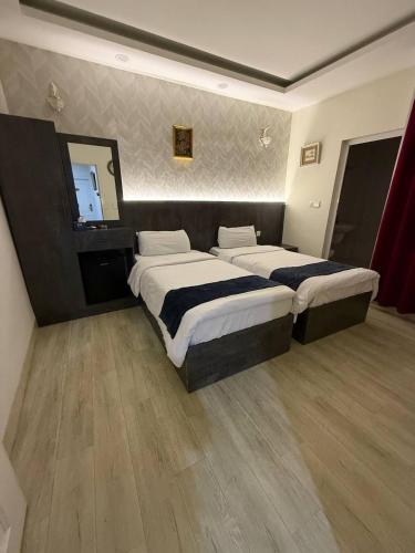 a bedroom with two beds and a large mirror at Vote Hotel 1 in Erbil