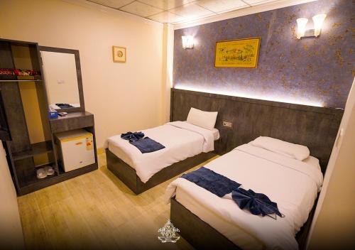 a hotel room with two beds and a mirror at Vote Hotel 1 in Erbil
