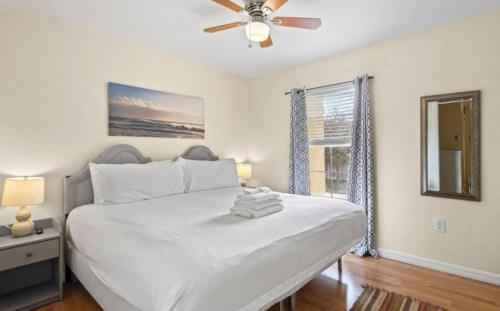a bedroom with a white bed and a ceiling fan at Lovely 3bd Home With Bbq in Orlando