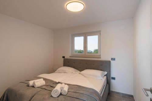 a bedroom with a bed with two towels on it at Villa Rosemary Trieste HerMes arT in Sežana