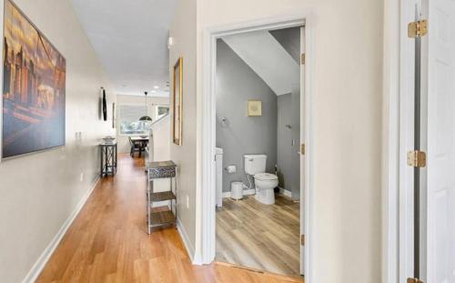 a hallway with a bathroom with a toilet and a staircase at Lovely 3bd Home With Bbq in Orlando