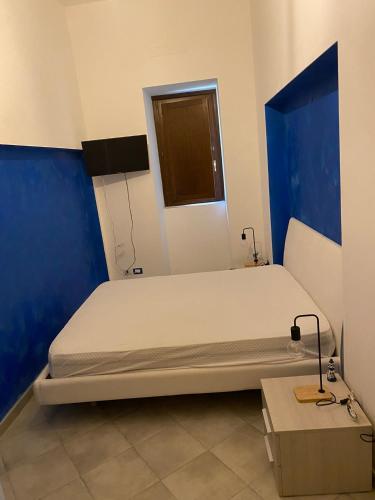 a bedroom with a large bed with a blue wall at Casa Vacanze Centro Storico in Centola