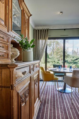 a living room with a large wooden cabinet and a table at Hotel Restaurant Crystal in Erstein
