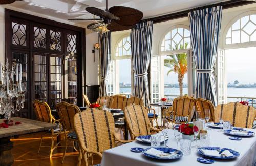 una sala da pranzo con tavoli, sedie e finestre di Bordoy Grand House Algarve a Vila Real de Santo António