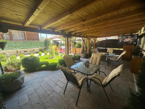 a patio with a table and chairs and a piano at NIKI HOUSE in Bansko