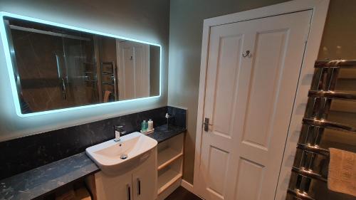 a bathroom with a sink and a mirror at Dunperrogh in St. Andrews
