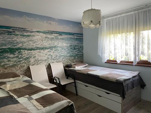 two beds in a room with the ocean on the wall at Къща за гости, Guesthouse GOTINOTO in Krapets