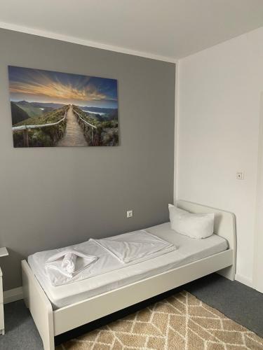 a bed in a room with a painting on the wall at GoldStar Apartment-ganze Ferienwohnung Hannover-Sarstedt in Sarstedt