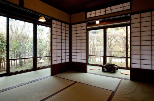 an empty room with windows and a stove at Motoyu Ishiya in Kanazawa
