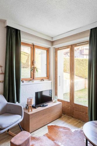 un salon avec une télévision sur une table en bois dans l'établissement One-bedroom apartment with garden, à Megève