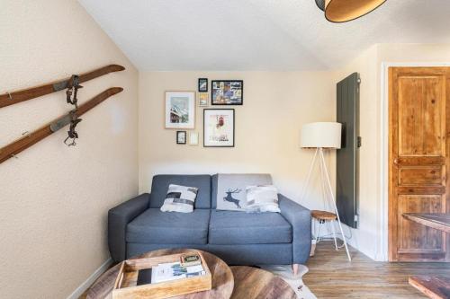 un salon avec un canapé bleu et une table dans l'établissement One-bedroom apartment with garden, à Megève