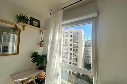 une fenêtre avec vue sur un grand bâtiment dans l'établissement Cosy studio for 2 persons, à Marseille