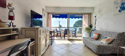 Il comprend un salon avec un canapé et une cuisine avec un balcon. dans l'établissement 1 bedroom apartment - sea view, à Fréjus