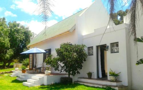 a white house with a table and an umbrella at Soli Deo Gloria in McGregor