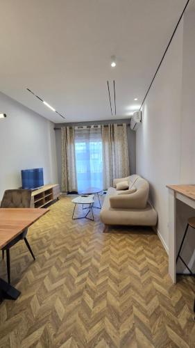 a living room with a couch and a table at Tirent Apartment-Modern Bedrooms Stay Near Liqeni i Thatë in Tirana