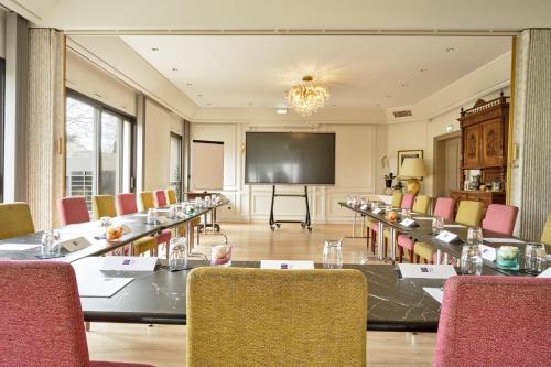 a conference room with a long table and a projection screen at Hotel Restaurant Crystal in Erstein