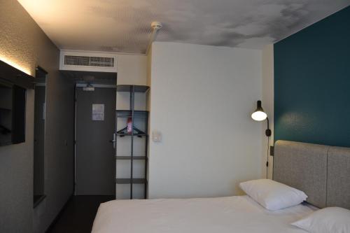 a room with a bed and a wall with a shelf at ibis Chambery in Chambéry
