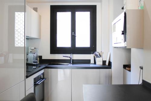 une cuisine avec un évier et une fenêtre dans l'établissement Beautiful apartment of 80 m2 near wood of Boulogne, à Paris