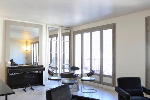 - un salon avec un bureau et des chaises dans l'établissement Beautiful apartment of 80 m2 near wood of Boulogne, à Paris